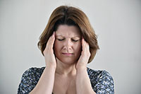 Picture of stressed woman holding her head in her hands